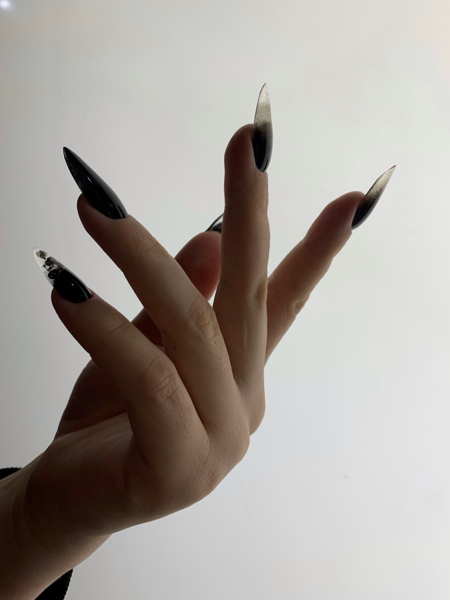 a woman's hand with black and silver nails