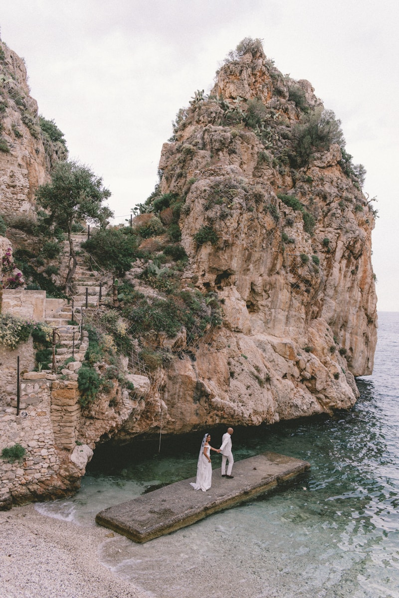 Two people standing on a dock in the water